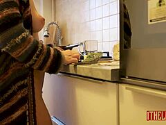 Aantrekkelijke vrouw kokt naakt in de keuken