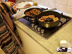 Une femme au foyer sensuelle prépare un dîner rapide dans la cuisine avec son vagin poilu