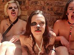 Tre donne nude si impegnano in giochi di lingua kinky all'aperto