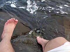 Duże i owłosione stopy Mika cieszą się zabawą bosymi stopami w wodzie